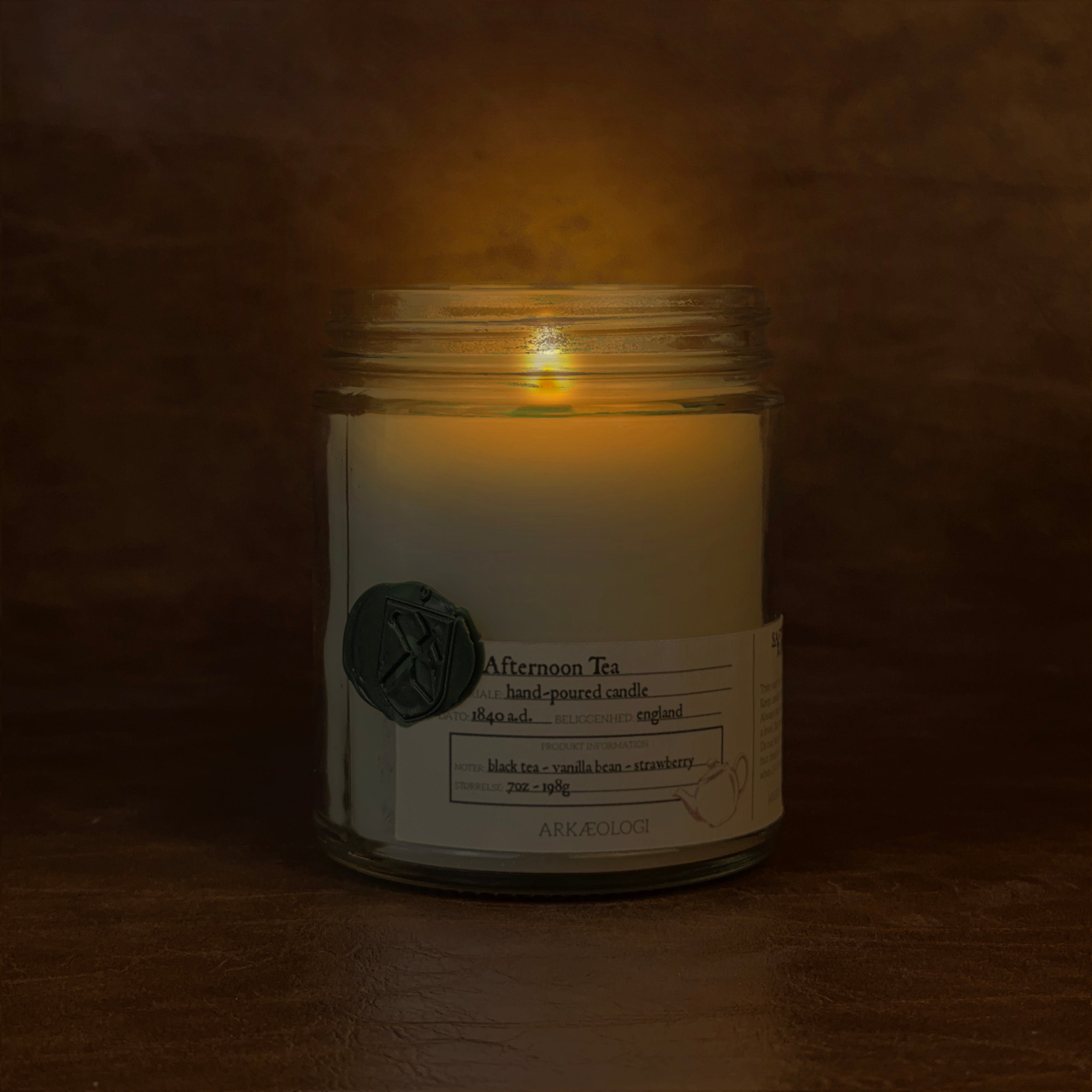 Lit Afternoon Tea candle jar on map background