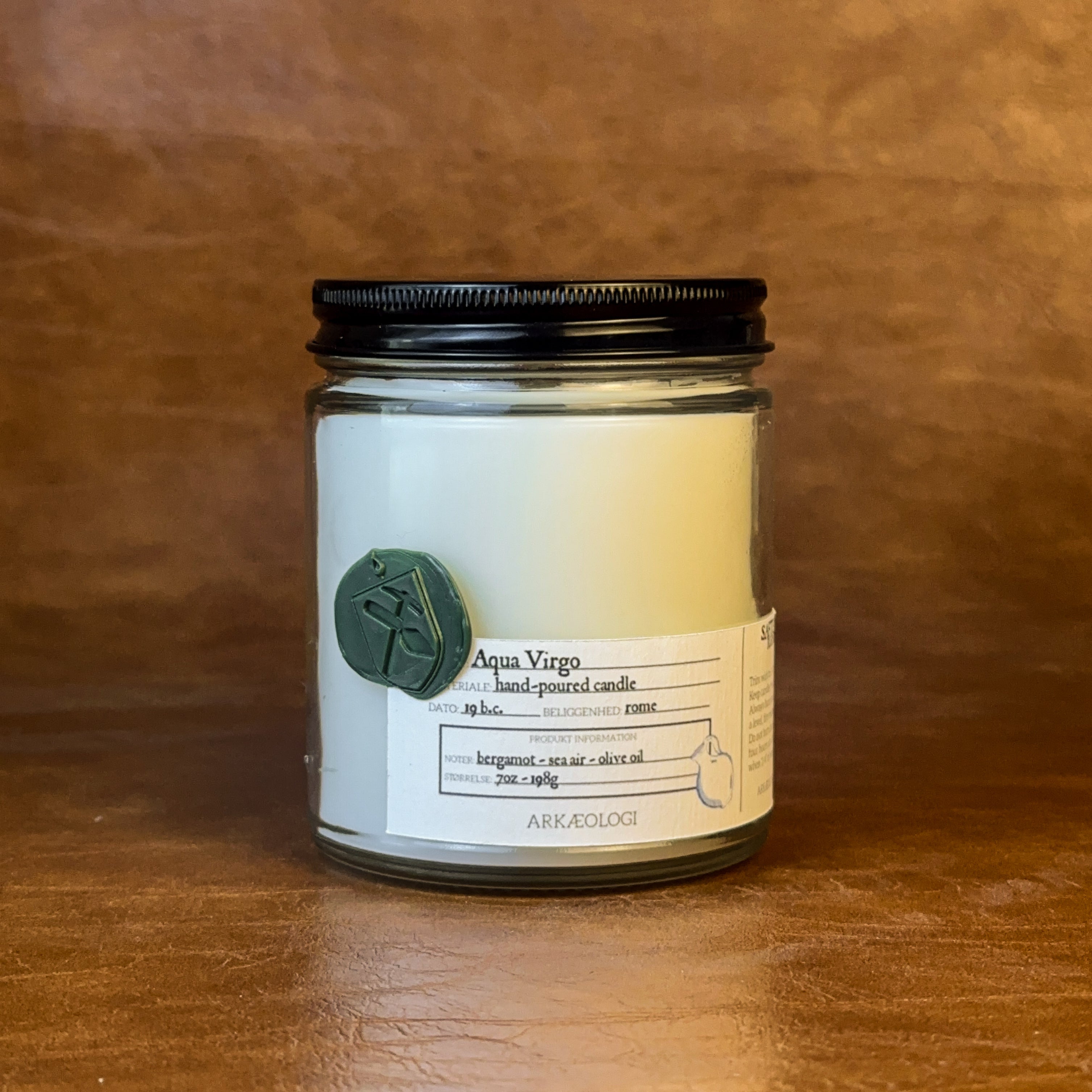 Aqua Virgo candle with black lid on map background