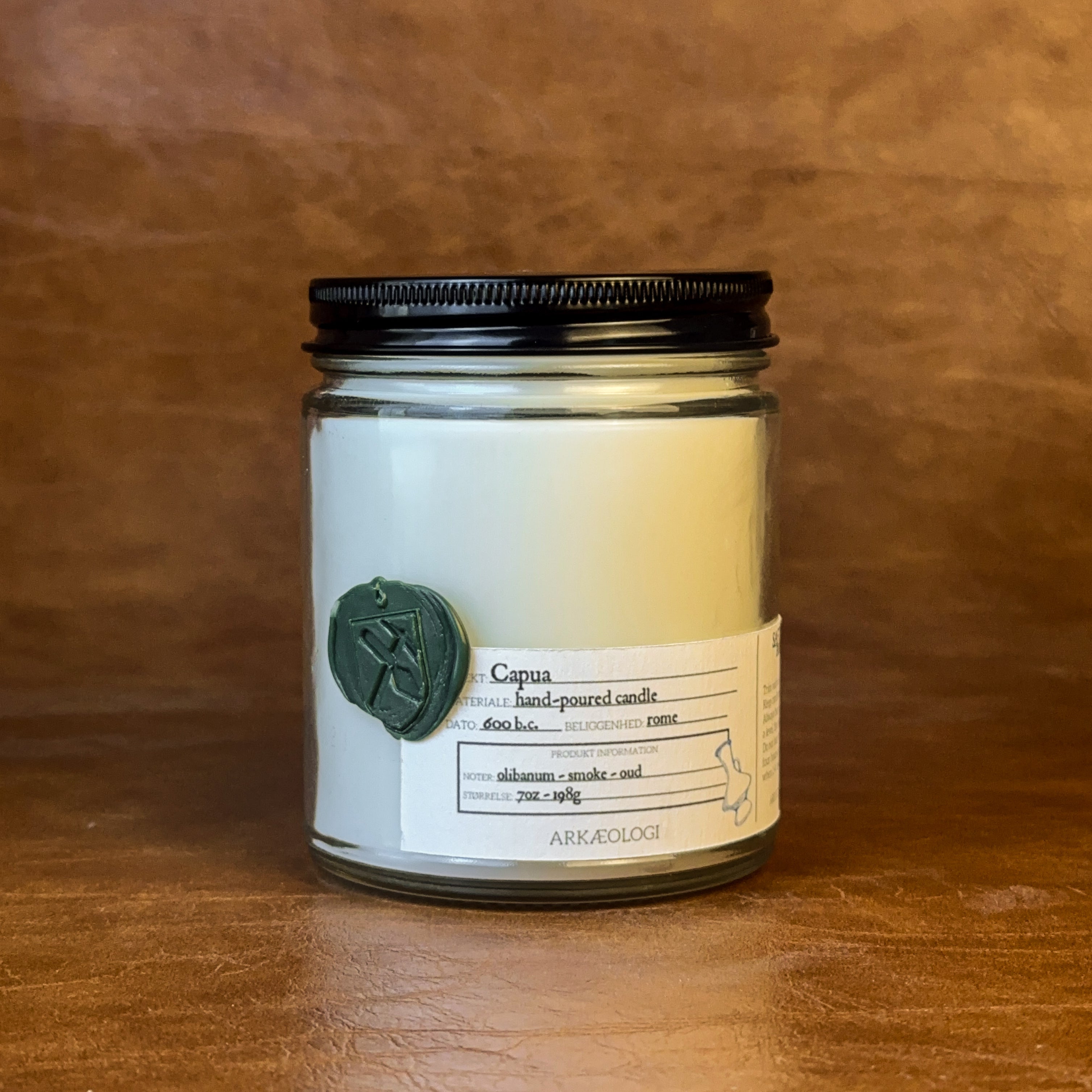 Capua candle with black lid on map background