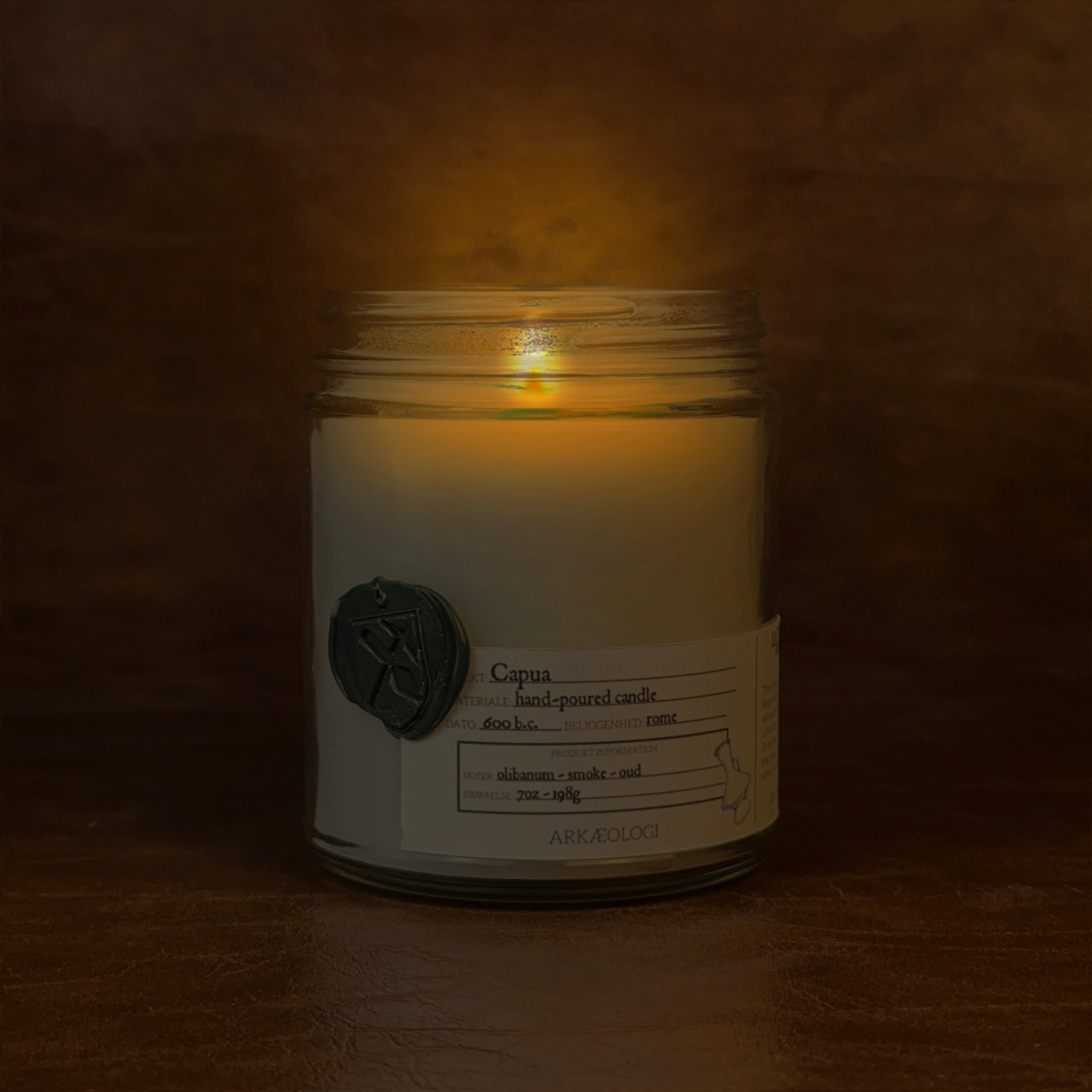 Lit Capua candle jar on map background