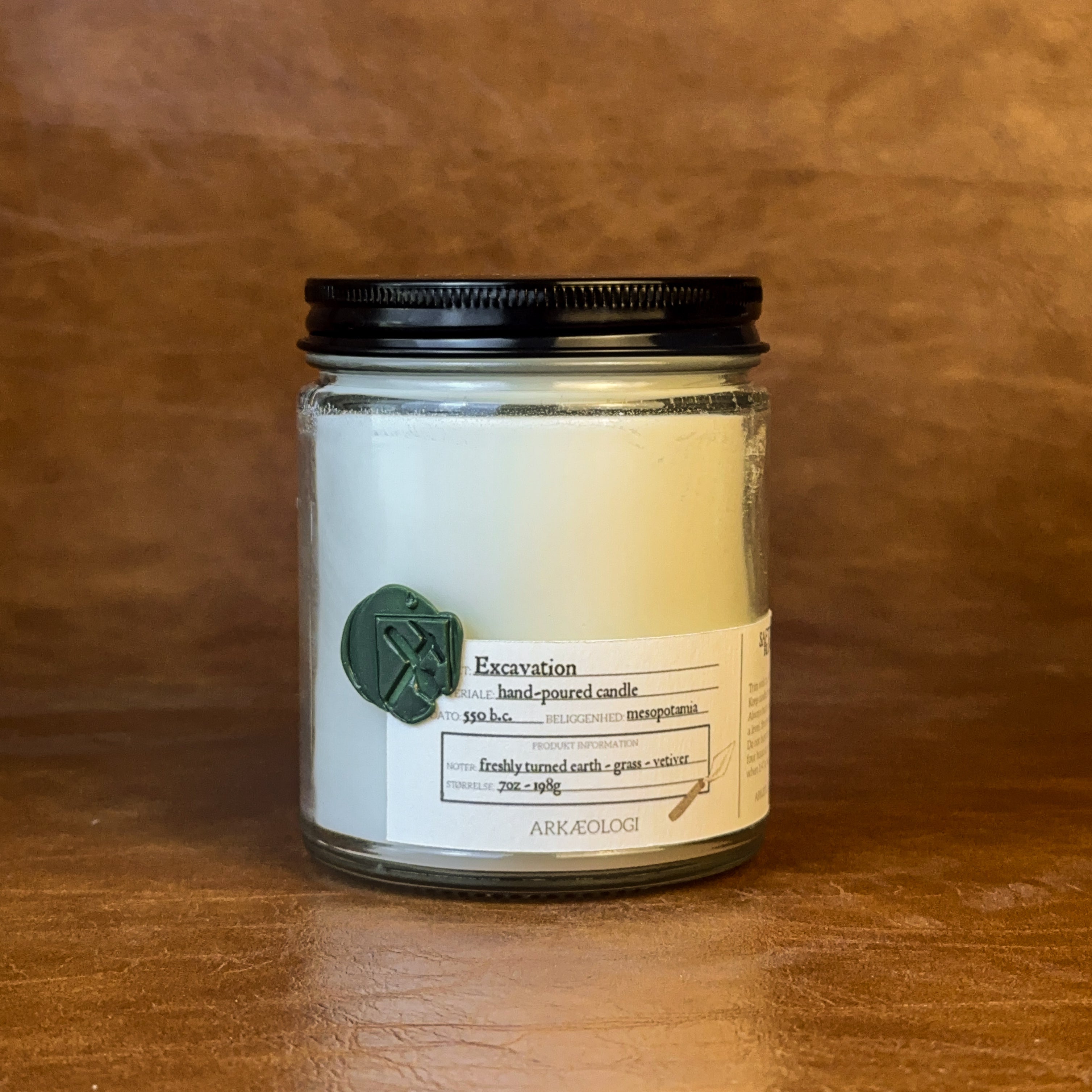 Excavation candle with black lid on map background