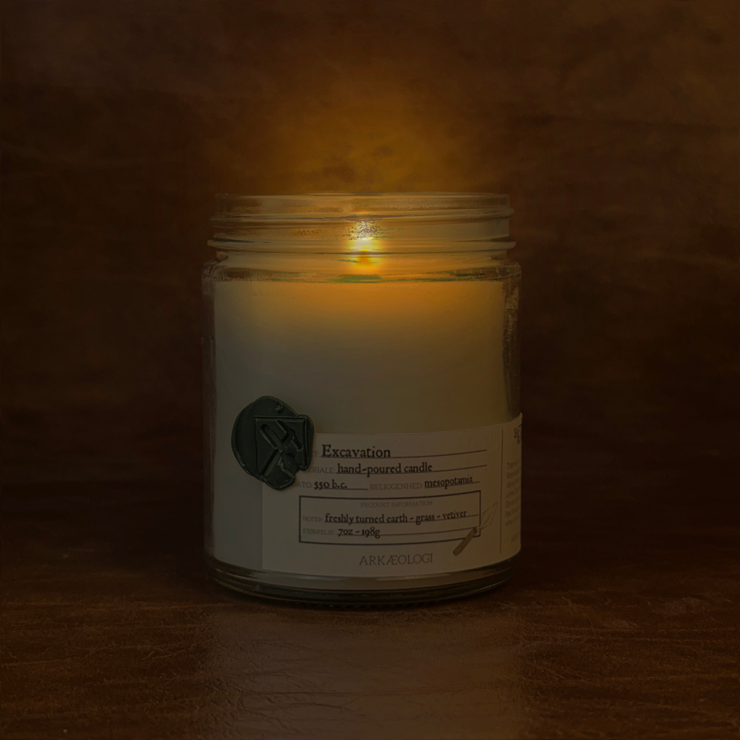 Lit Excavation candle jar on map background