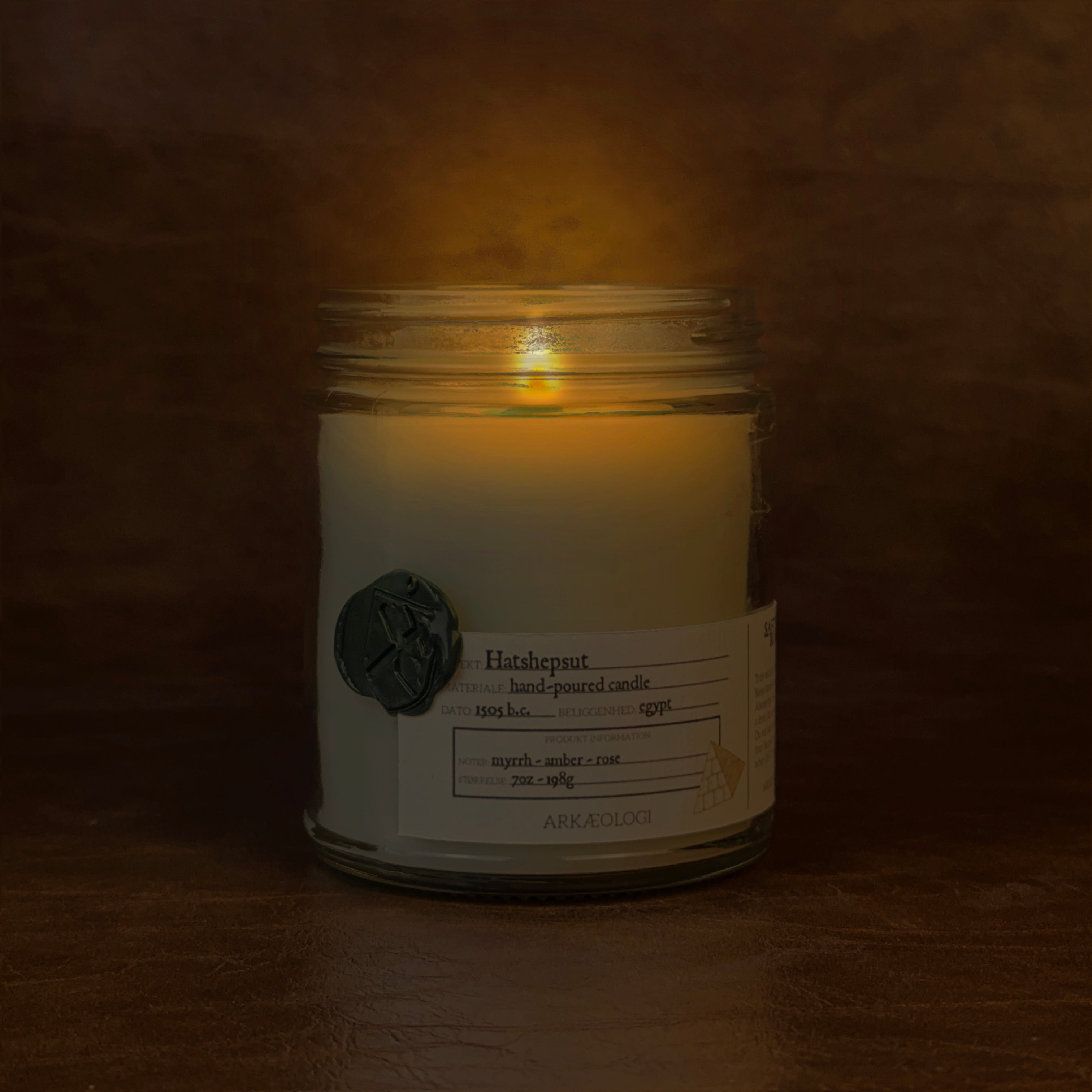 Lit Hatshepsut candle jar on map background