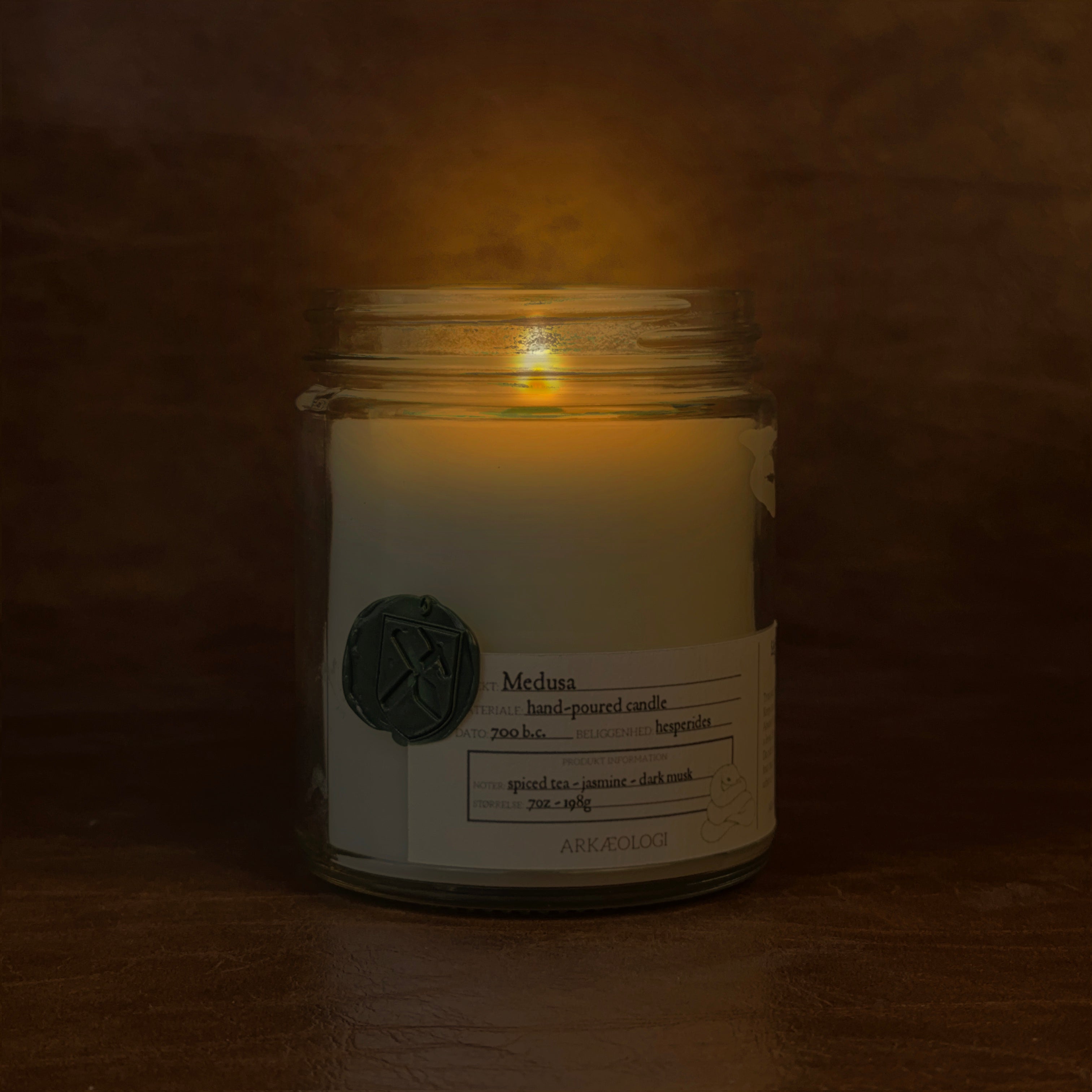 Lit Medusa candle jar on map background