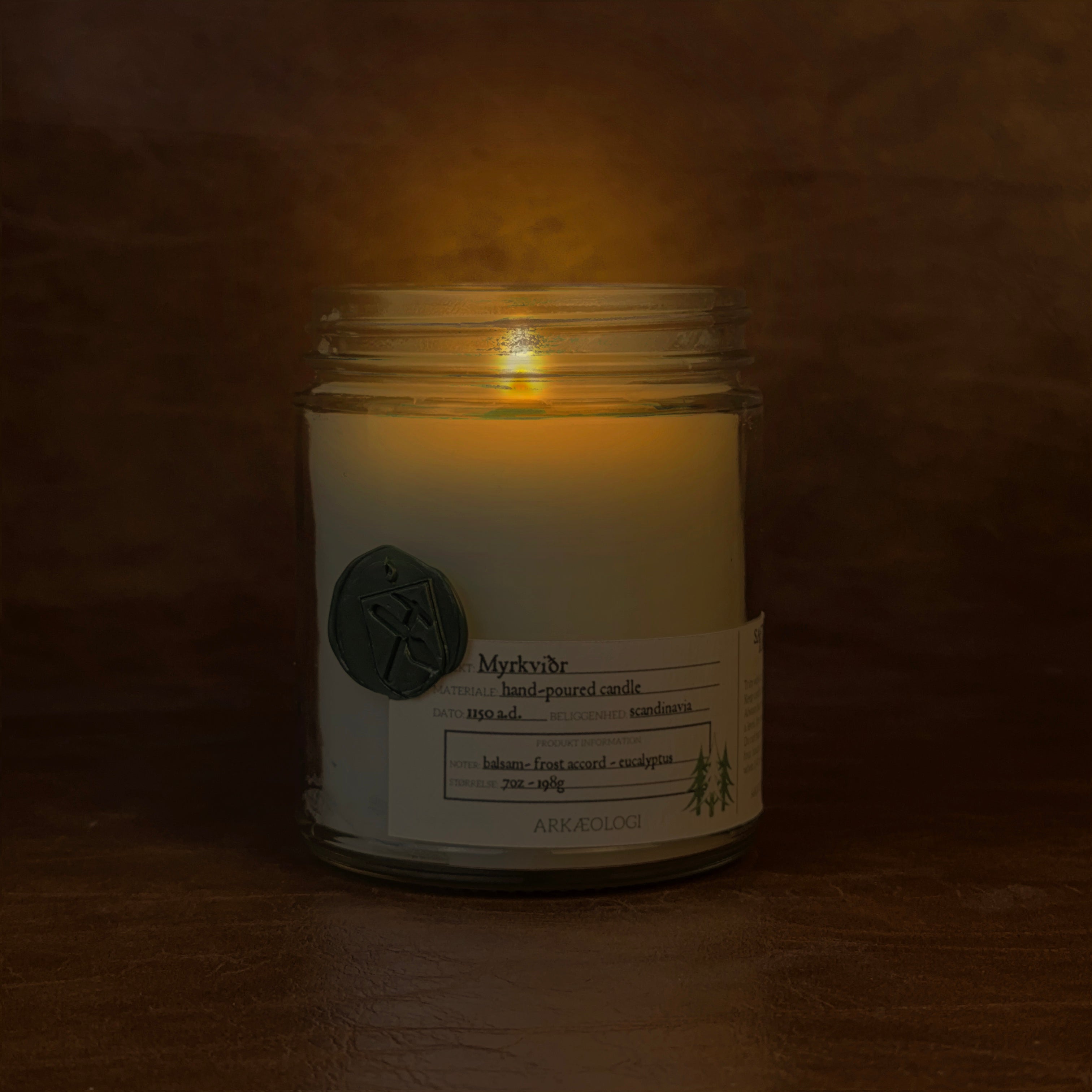 Lit Myrkviðr candle jar on map background