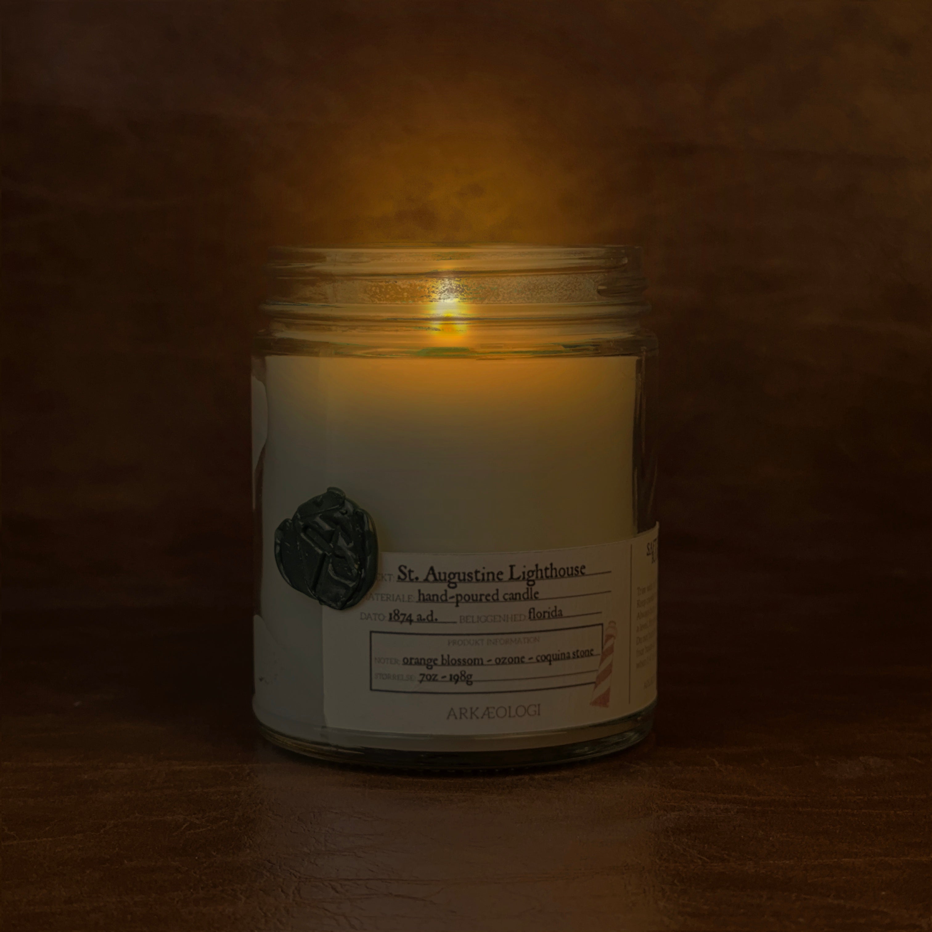 Lit Saint Augustine Lighthouse candle jar on map background