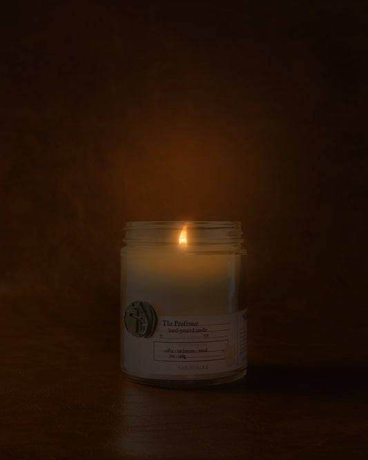 Lit The Professor in clear jar with green wax seal and white label inspired by artifact tag on leather background