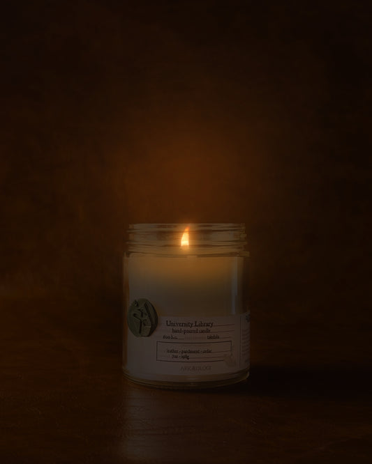 Lit University Library in clear jar with green wax seal and white label inspired by artifact tag on leather background