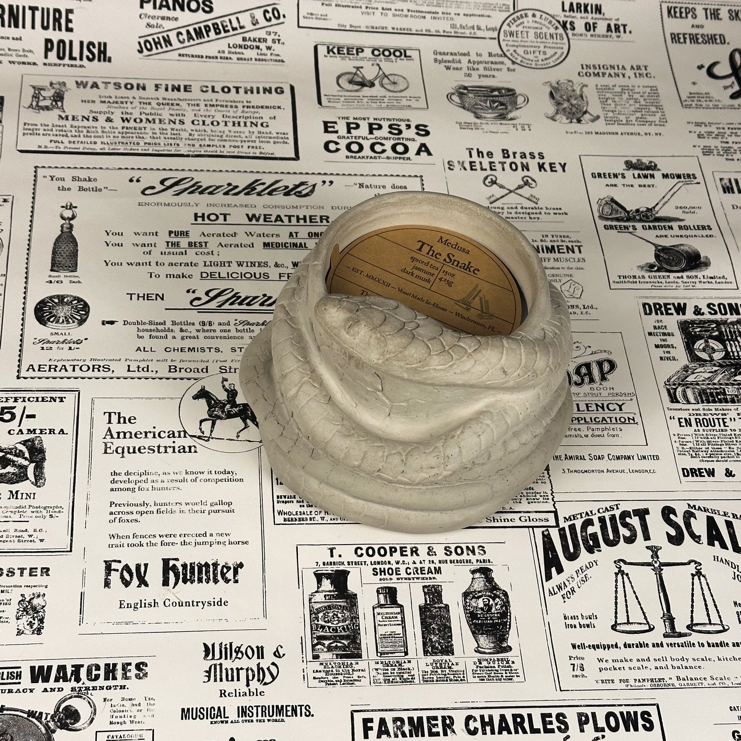 White concrete snake candle on vintage newspaper background